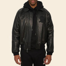Load image into Gallery viewer, Person wearing a black leather jacket with a brand logo on a beige background