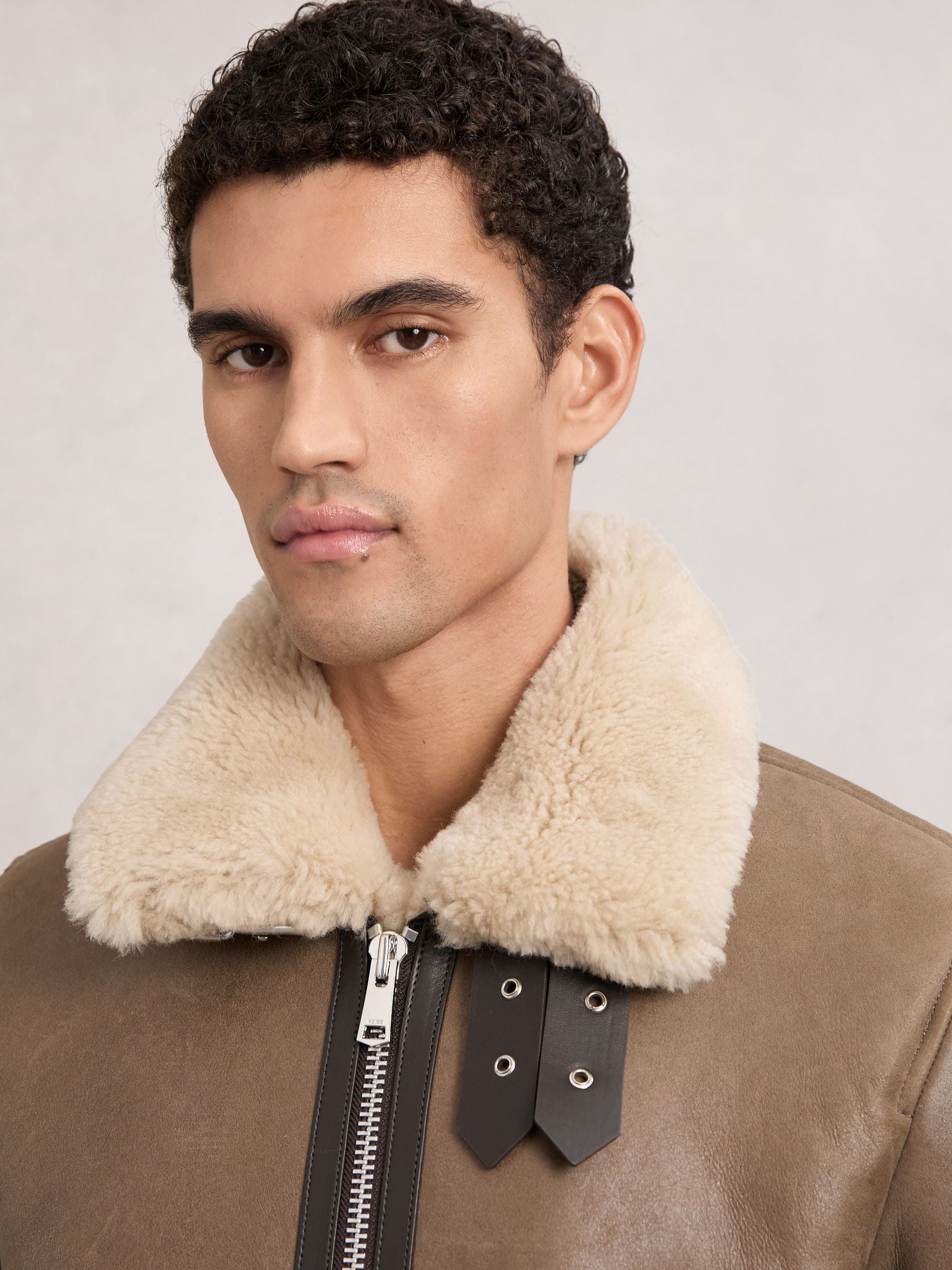 Cream turn-down shearling collar with leather throat straps