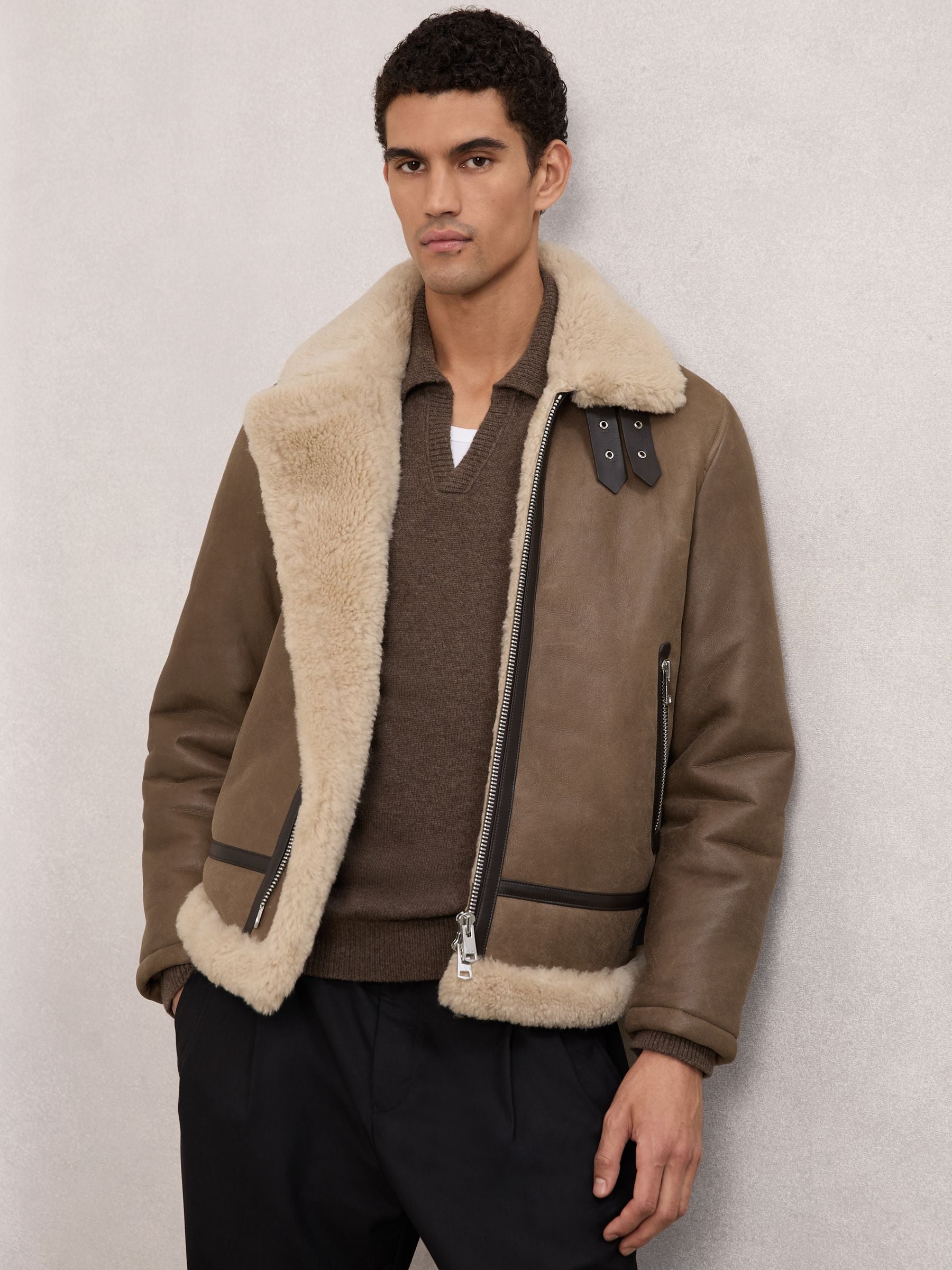 Man wearing a light brown B3 shearling bomber jacket open