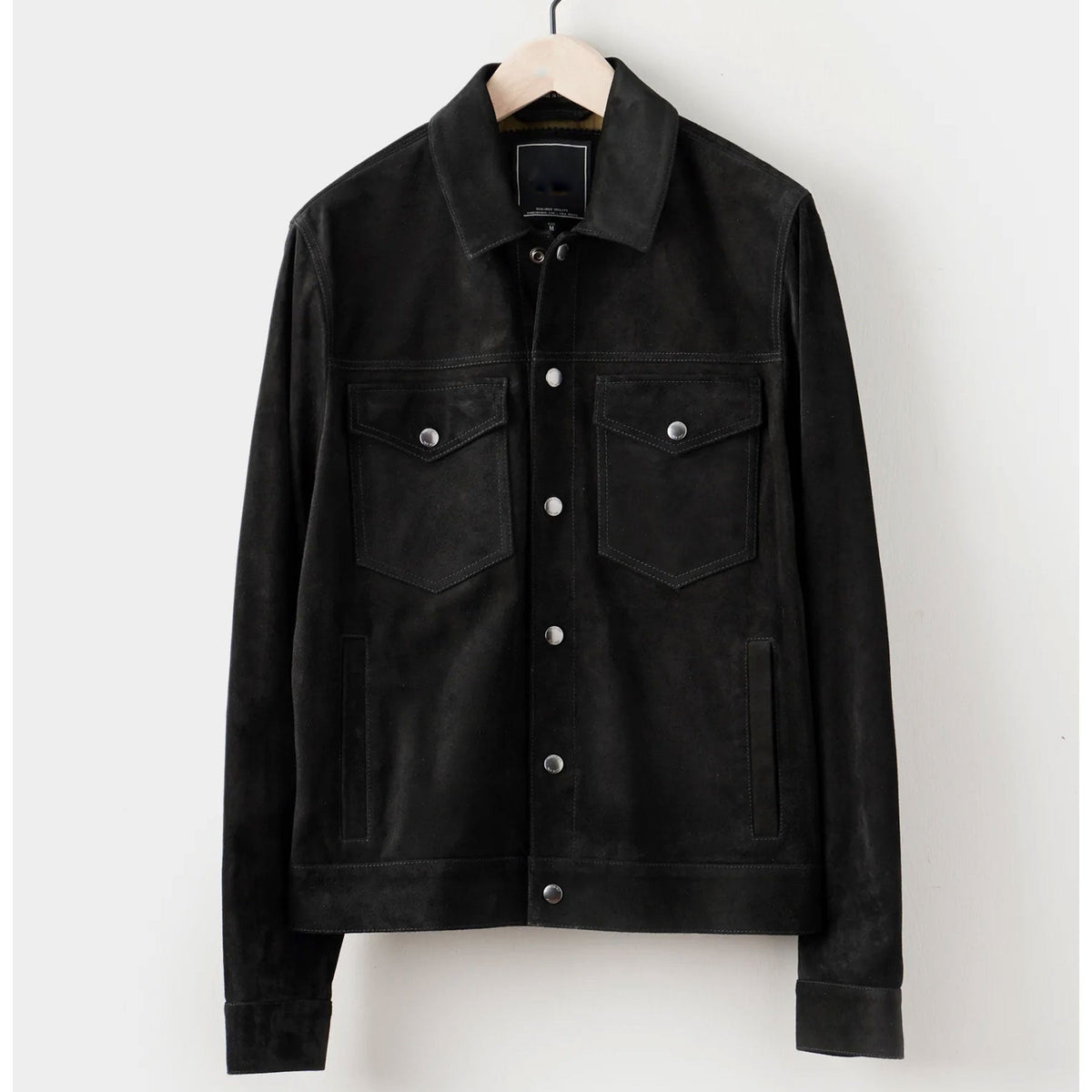 black suede leather jacket hanged on hanger.