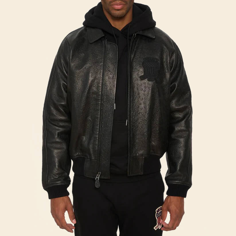 Person wearing a black leather jacket with a brand logo on a beige background