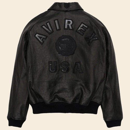 Black leather jacket with 'AVIREX USA' branding on a beige background