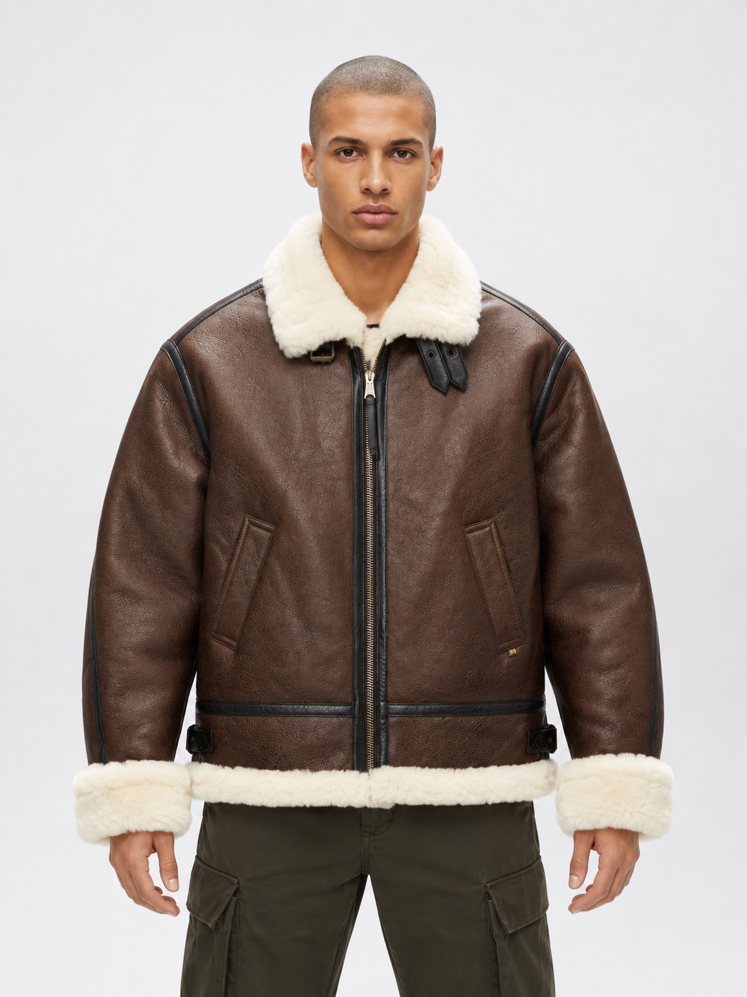 Model wearing men’s brown B3 shearling bomber jacket with cream collar, turn-back cuffs and straight fur hem