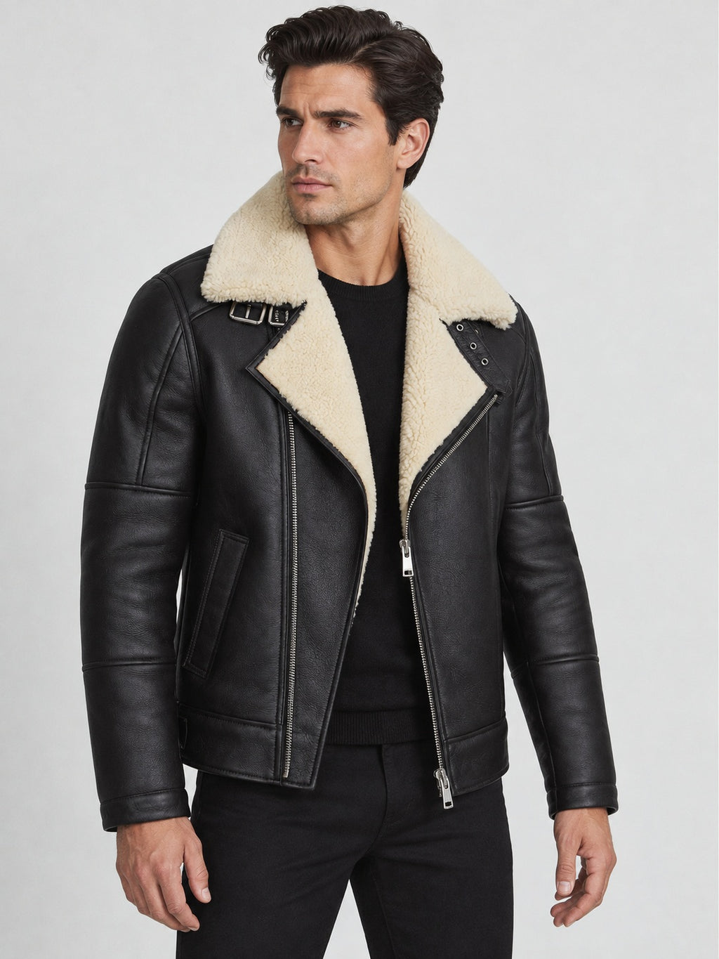 Model wearing men’s black shearling aviator biker jacket with cream collar and asymmetric metal zipper