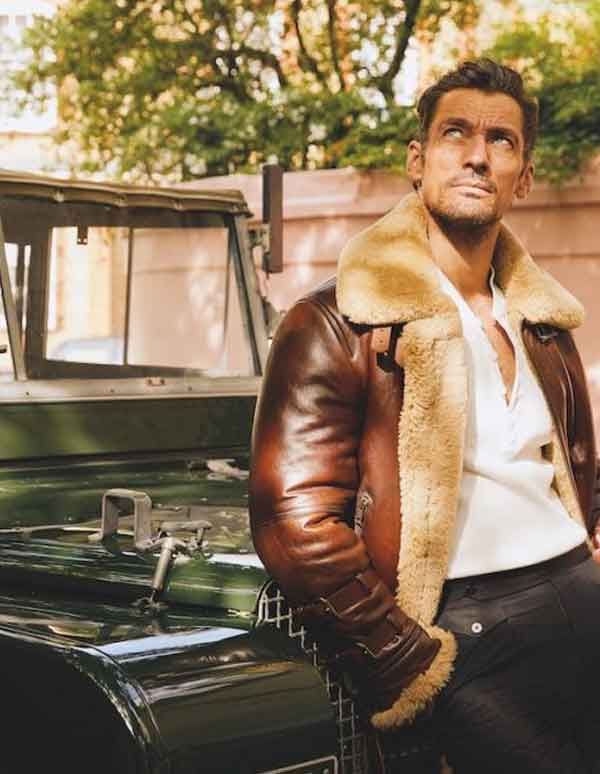 man wearing shearling leather jacket and standing in front of a Jeep