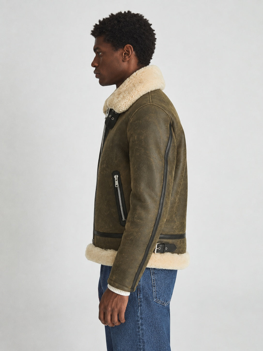 Side view of army green sheepskin shearling jacket showing sleeve binding and waist adjuster