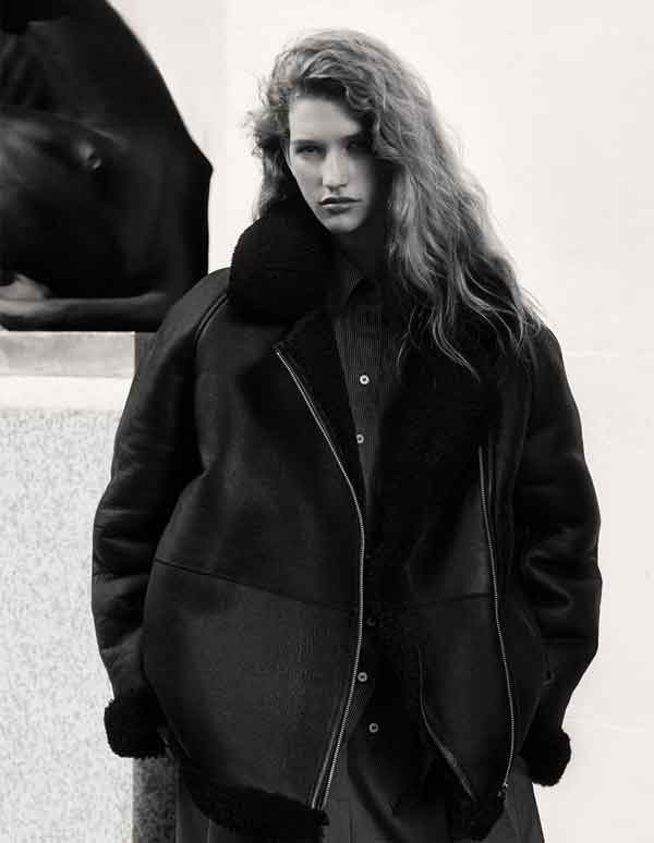 black and white photo of white women wearing black shearling jacket.