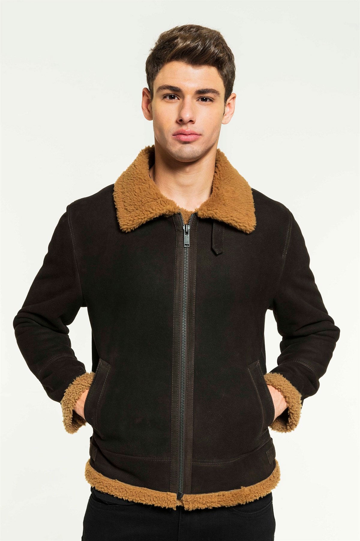 A man wearing a black aviator shearling jacket with a standing collar and zipper details.