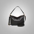 A black sheepskin leather backpack with a shoulder strap and gold-tone hardware.