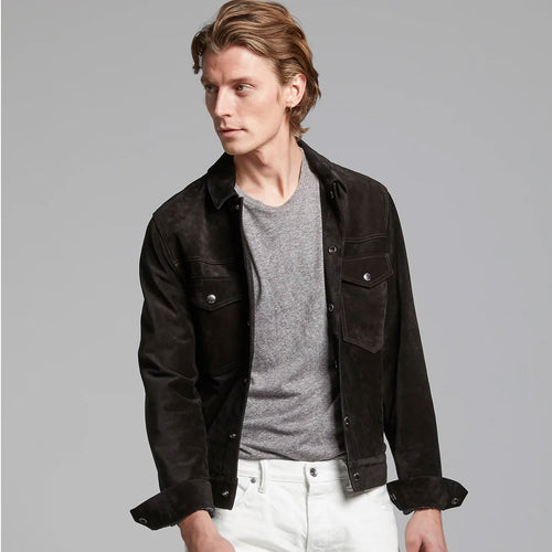A man wearing a black suede leather jacket with a classic jeans style, featuring a button closure and pockets on the chest.