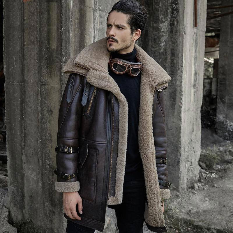 A man wearing a long brown shearling aviator fur coat with sheepskin leather and arm buckles.