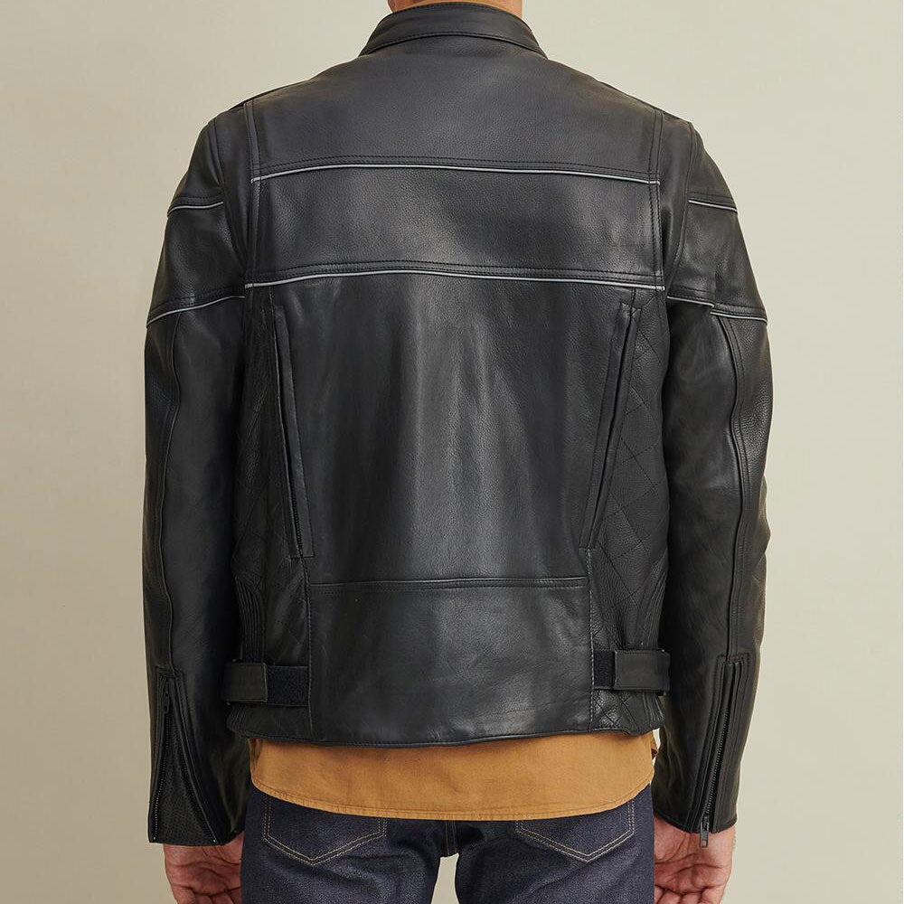 A man wearing a black leather rider jacket with a quilted design and covered front zipper, paired with a brown shirt and blue jeans.